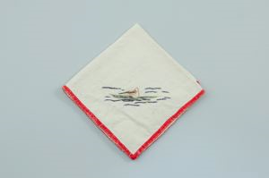 Image: A figure kayaking, one of a set of 3 embroidered napkins, each with unique scene